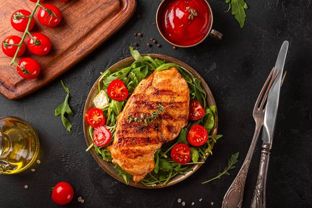 Grilled,Chicken,Breast,With,Arugula,And,Tomatoes,On,A,Plate,