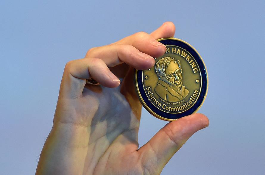 FILE PHOTO: British musician and astrophysicist May holds a medal as he attends a launch event for a new award for science communication, called the Stephen Hawking Medal for Science Communication, in London in Britain