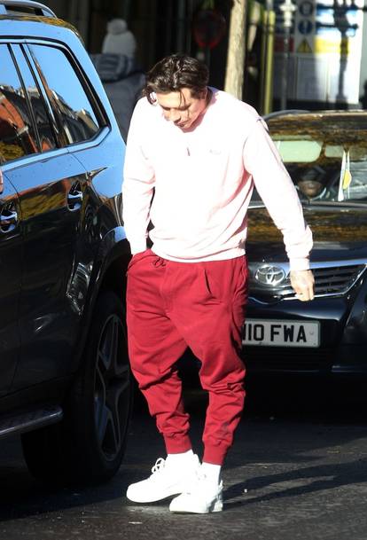 *EXCLUSIVE* WEB MUST CALL FOR PRICING  - David and Victoria Beckham's oldest son, Brooklyn Beckham is pictured spitting on a public street and grimacing in pain while seen wearing a bright pink jumper after visiting the dentist in London.
