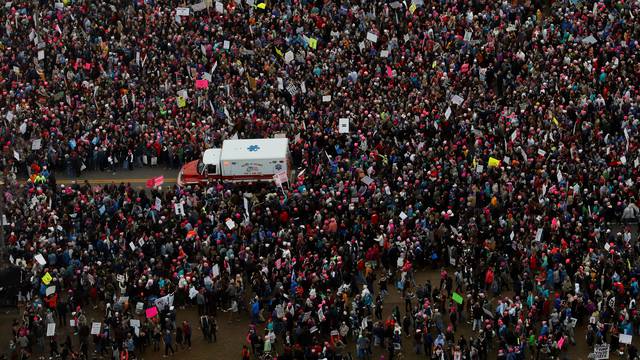 An ambulance drives through demonstrators taking part in the Women's March to protest Donald Trump's inauguration as the 45th president of the United States near the U.S. Capitol in Washington