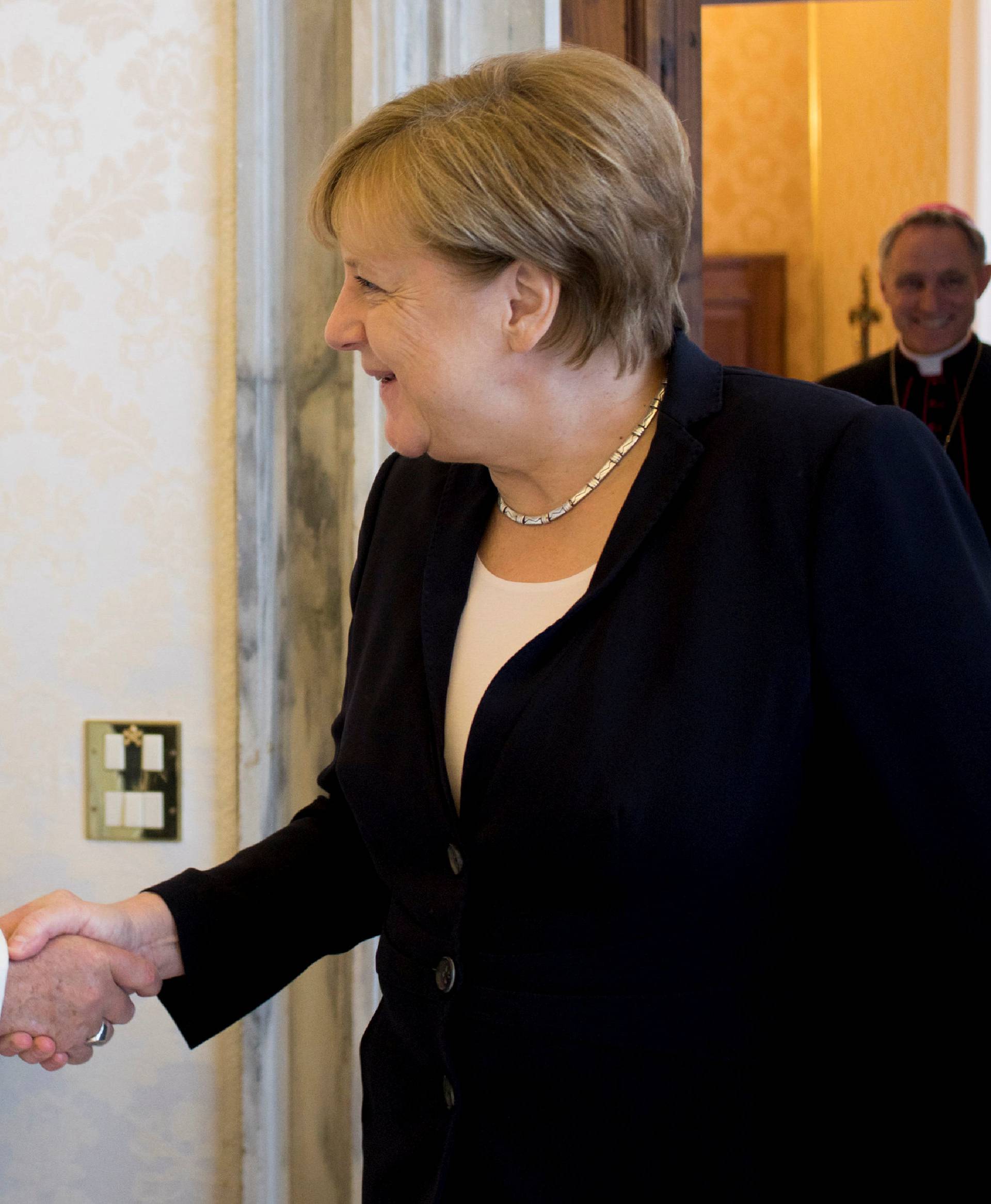 Pope Francis greets German Chancellor Angela Merkel during a meeting at the Vatican