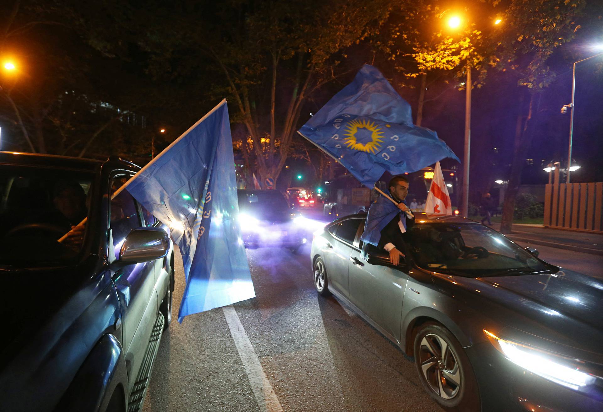 Supporters of the Georgian Dream party celebrate after the announcement of exit poll results in Tbilisi