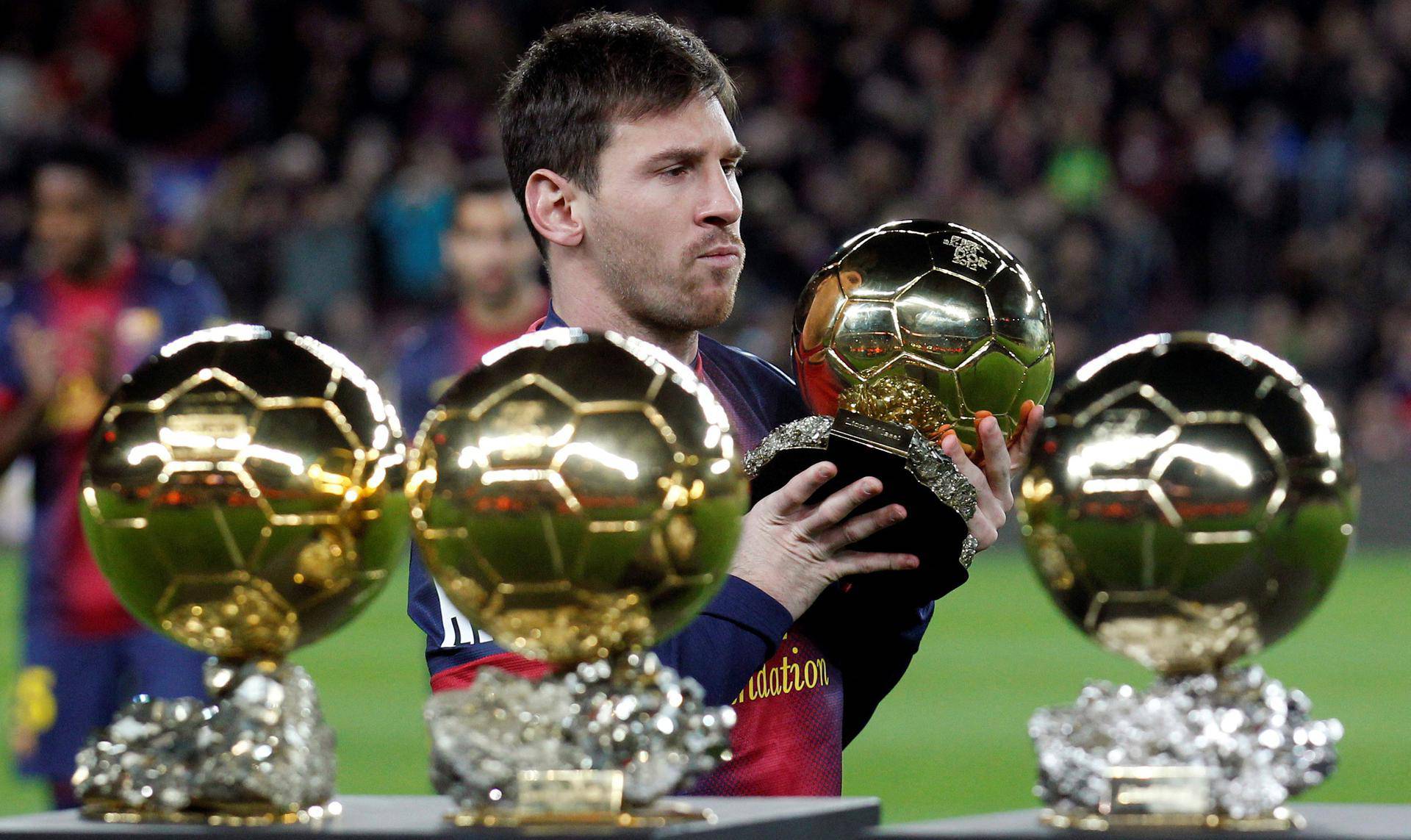 FILE PHOTO: Barcelona's Messi poses with his four Ballon d'Or trophies in Barcelona