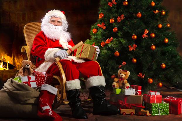 Santa Claus sitting in front of fireplace