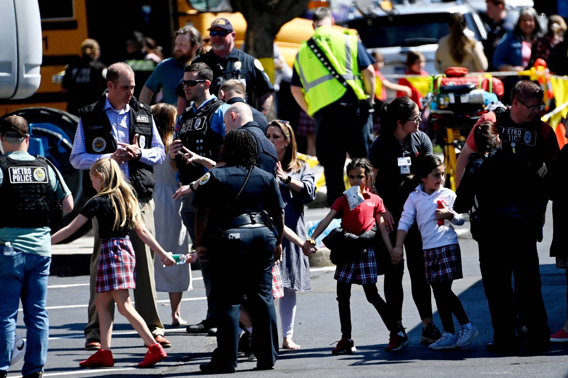 Students from the Covenant School hold hands after getting off a bus following a mass shooting in Nashville