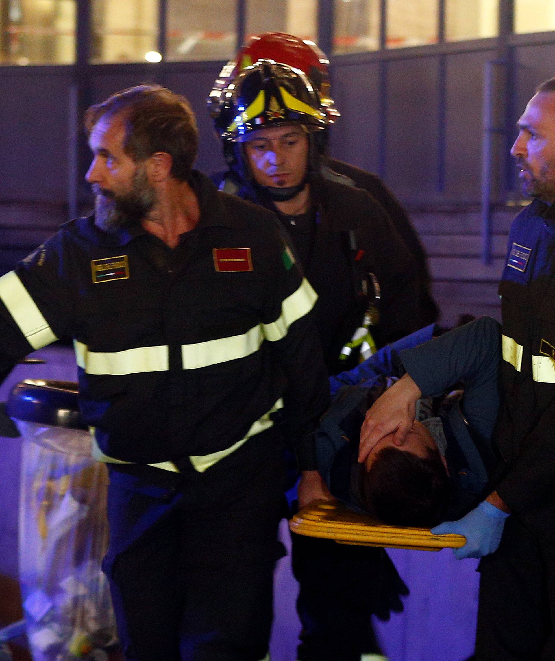 Fire fighters carry an injured person outside the underground where some of CSKA Moscow supporters were injured in Rome