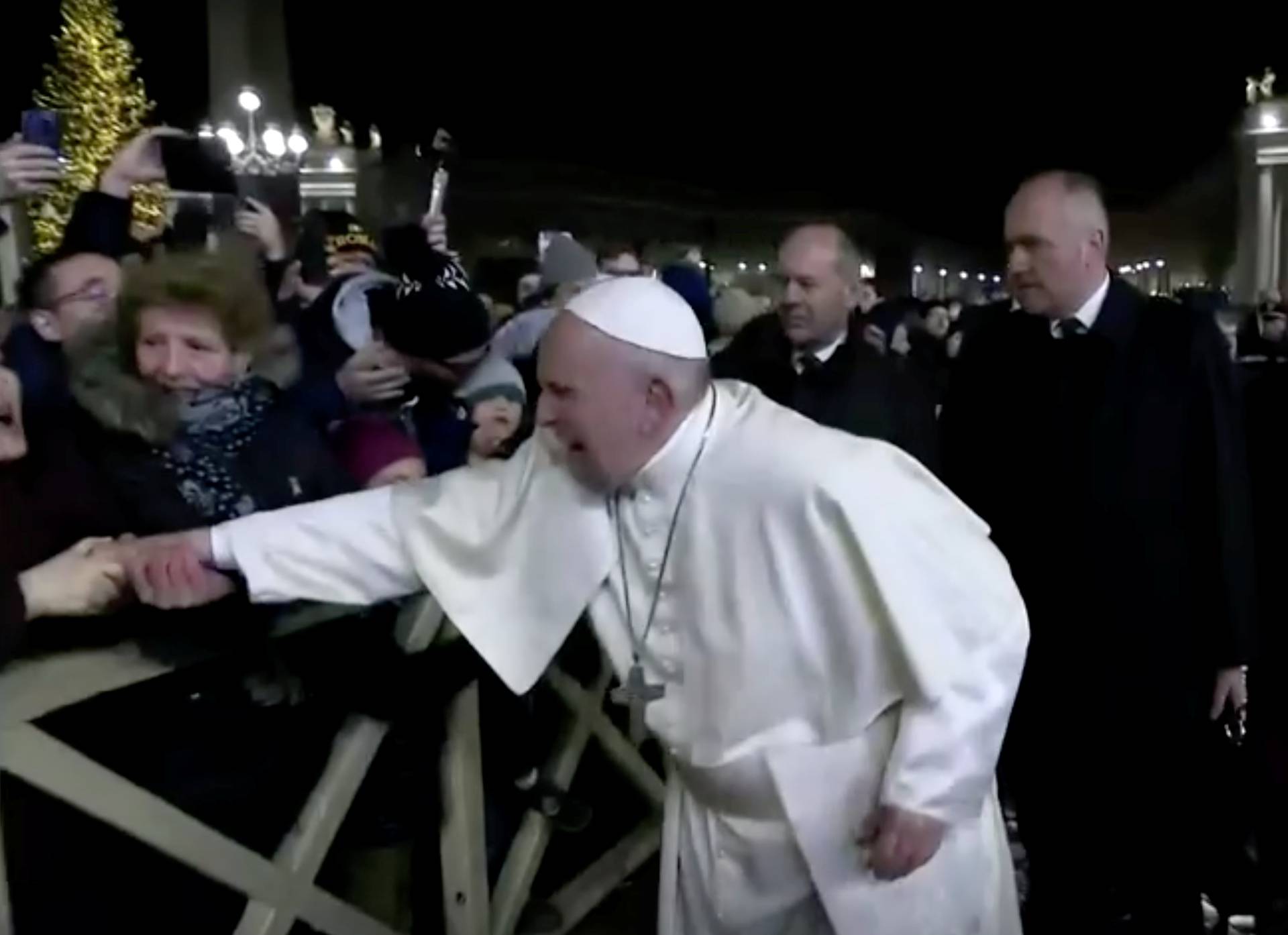 A woman grabs Pope Francis' hand and yanks him towards her, at Saint Peter's Square at the Vatican