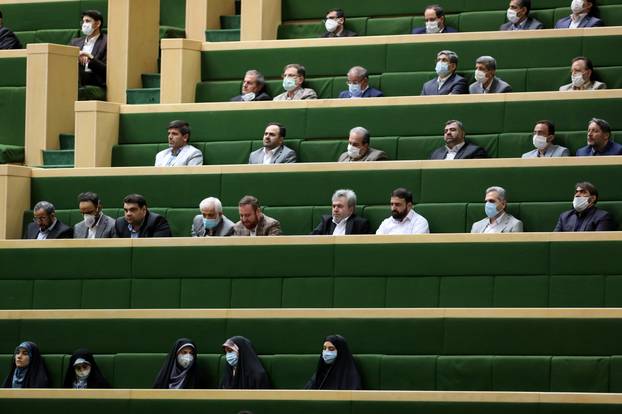 People wear protective face masks as they attend the opening ceremony of Iran