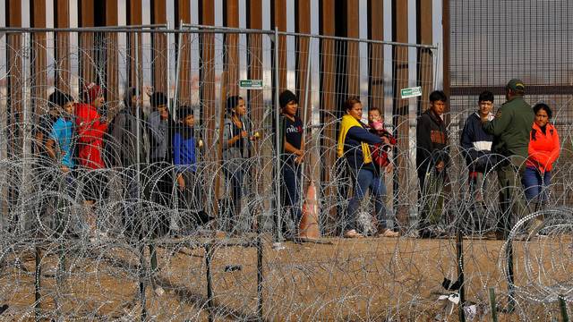 Migrants gather near U.S.-Mexico border fence, as seen from Ciudad Juarez