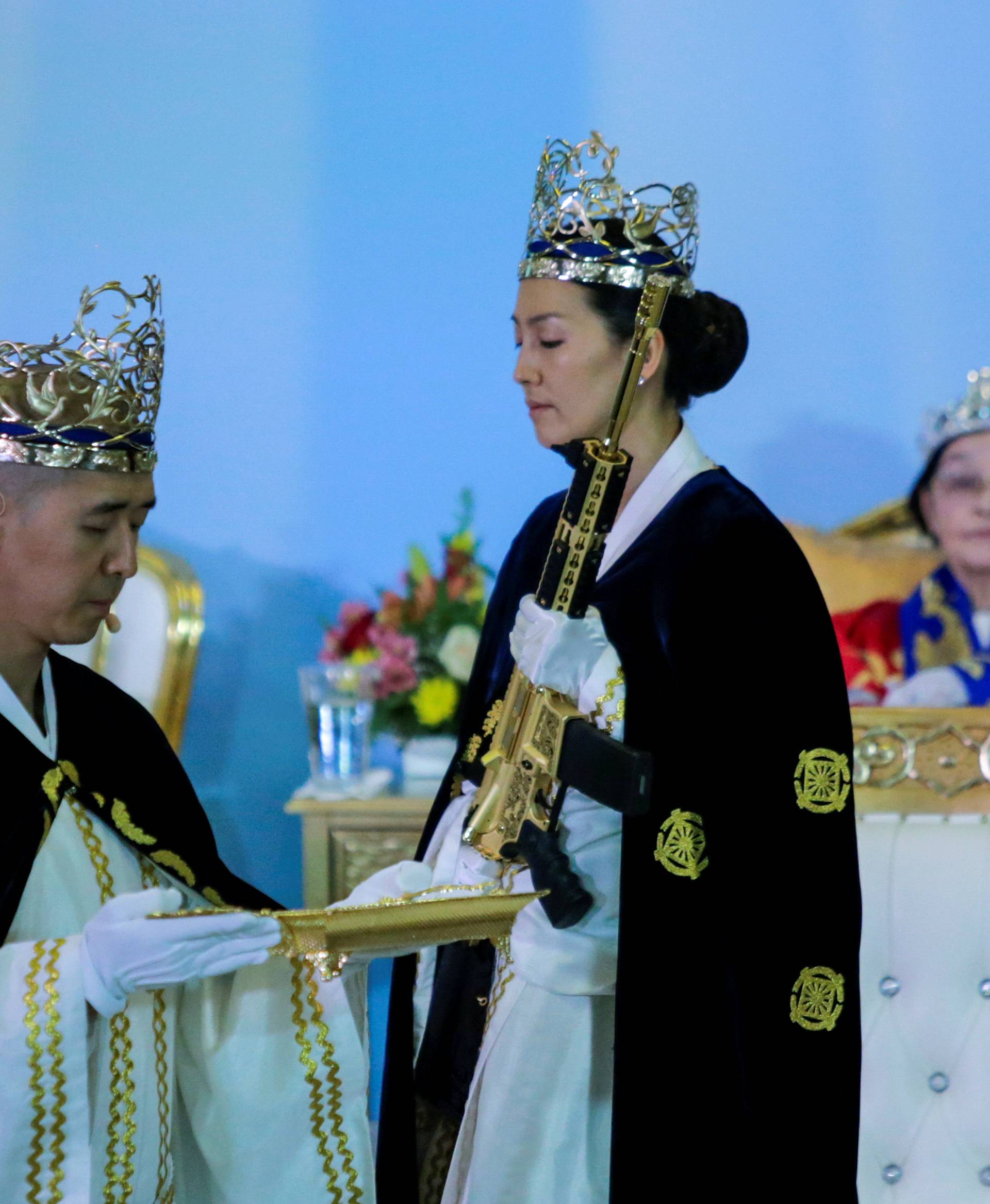 Reverend Hyung Jin Moon, the church's pastor and the son of the late Sun Myung Moon, attends a ceremony while people with their AR-15-style rifles in their cases watch the event at the Sanctuary Church in Newfoundland