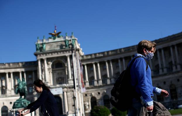 A man with a protective mask walks in front of Hofburg Palace during the global coronavirus disease (COVID-19) outbreak in Vienna