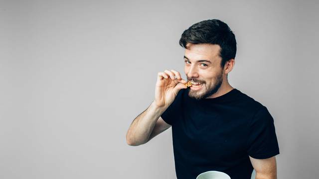 Man,Eats,Nuts,Isolated,On,A,Light,Background.,Man,Shows