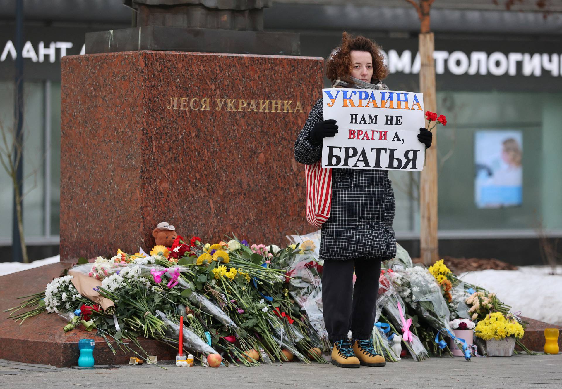 People lay flowers at a monument to Lesya Ukrainka in memory of the victims of the Russian missile strike in Dnipro, in Moscow