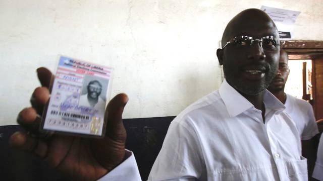 Weah, former soccer player and presidential candidate of CDC shows his voter's card in Monrovia