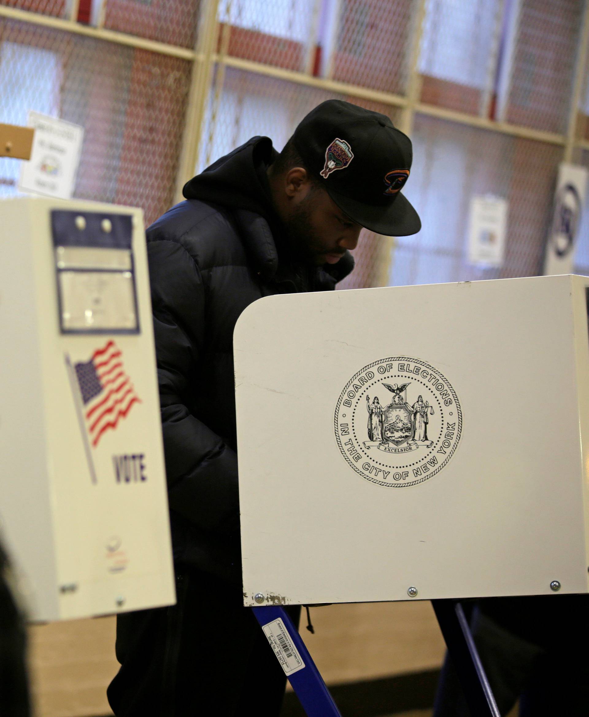 A voter casts his ballot behind a ballot booth during the U.S. presidential election at a polling station in the Bronx Borough of New York