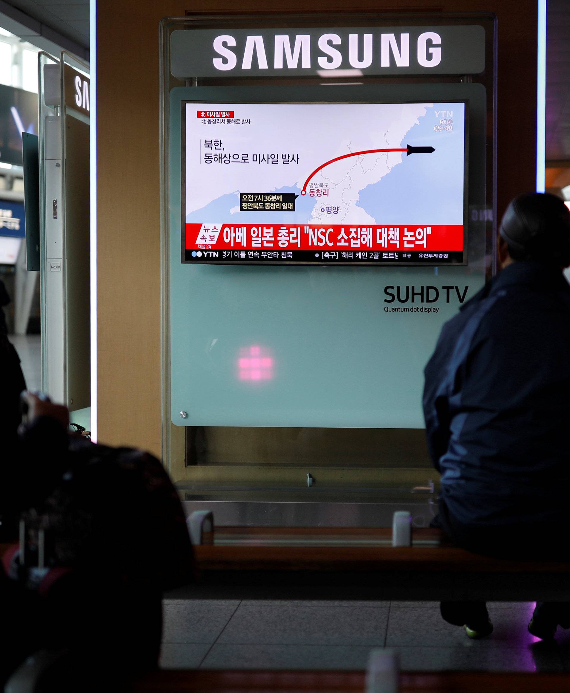 Passengers watch a television broadcasting a news report on North Korea firing ballistic missiles, at a railway station in Seoul