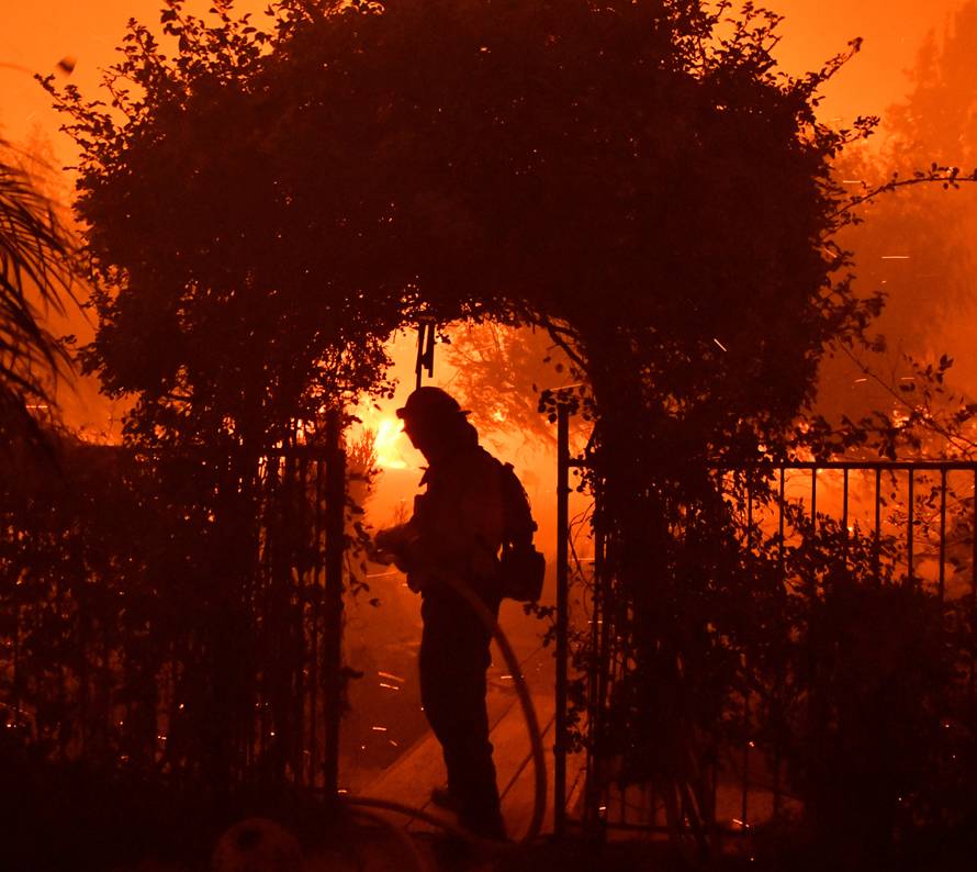 Firefighters battle a wind-driven wildfire called the Saddle Ridge fire in the early morning hours Friday in Porter Ranch