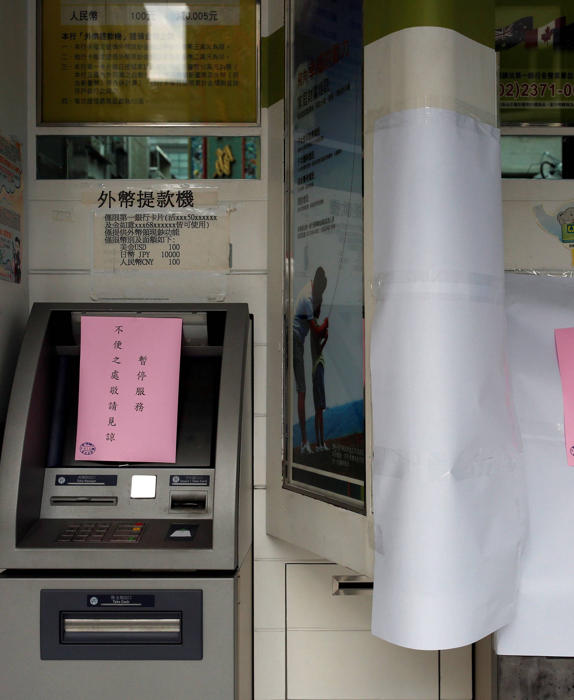 Taiwanese First Bank automated teller machines are seen suspended after T$70 million was reported stolen from its automated teller machines (ATM) in Taipei