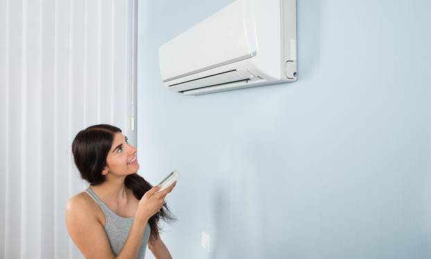 Woman Holding Remote Control Air Conditioner