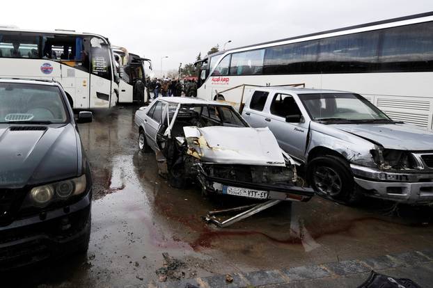 Damaged vehicles are pictured at the site of an attack by two suicide bombers in Damascus