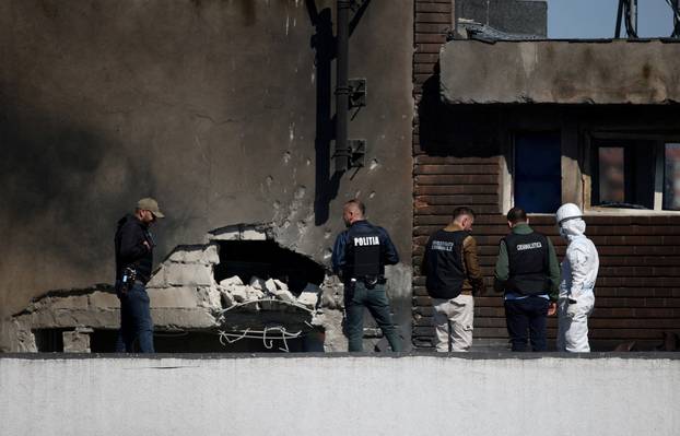 Law enforcement work on the site of an explosion at a residential block of flats following a drone hit in Galati