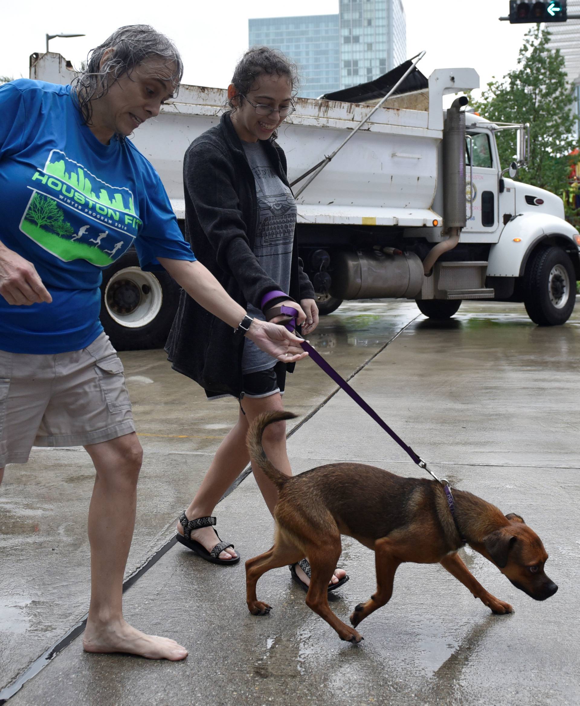 Evacuees Robin Alter and her daughter Melissa Alter walk their dog Dexter into the George R. Brown Convention Center after Hurricane Harvey inundated the Texas Gulf coast with rain causing widespread flooding