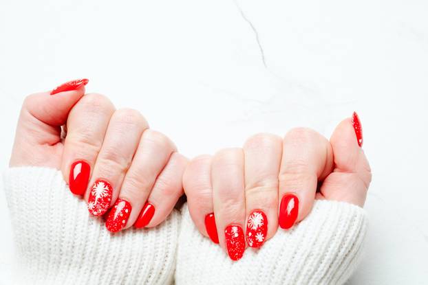 Christmas manicure, Beatiful red nails on white background.