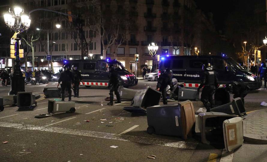 Catalan police remove trash bins used as barricades by protestors during skirmishes after former regional president Carles Puigdemont was detained in Germany,  in Barcelona