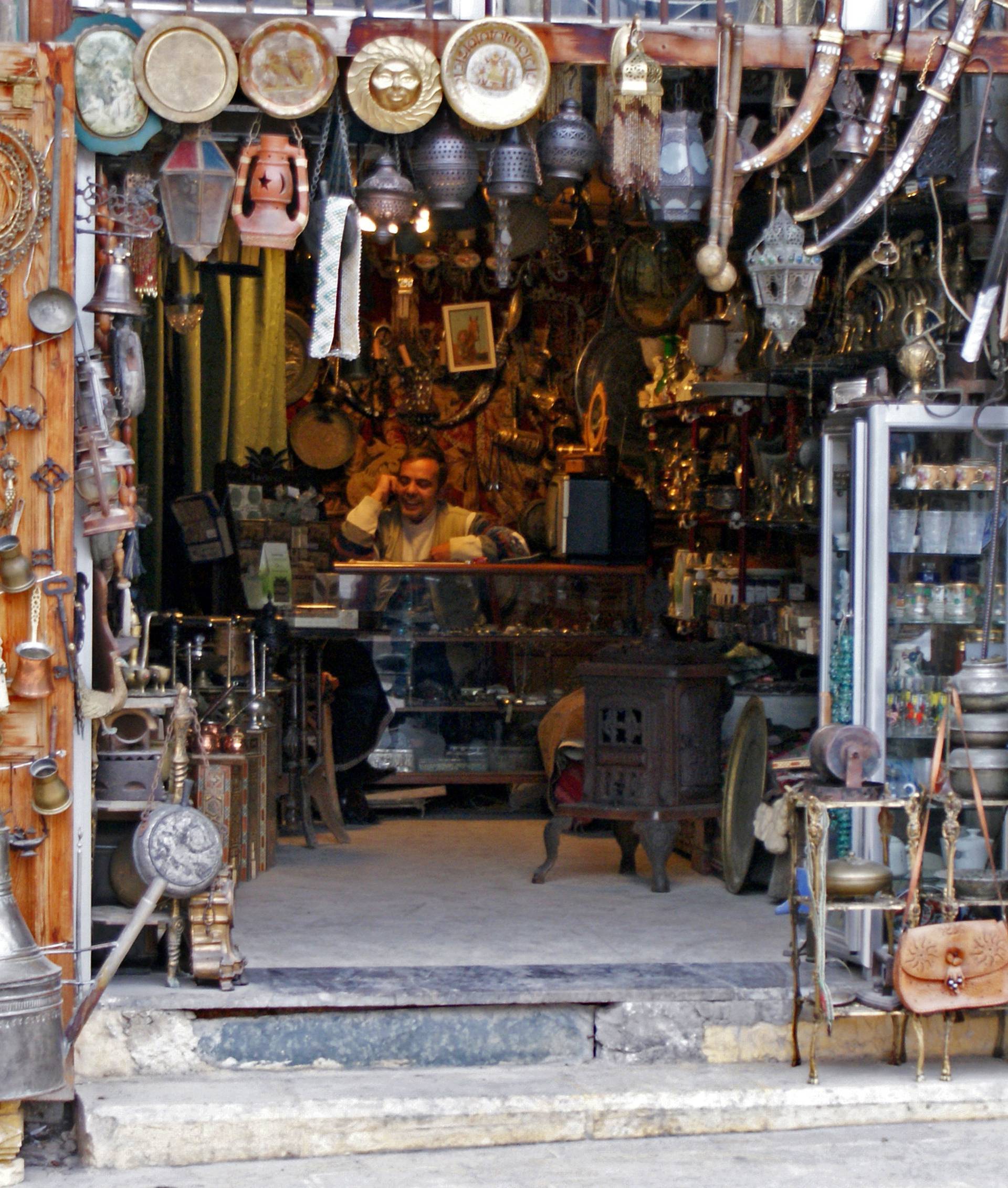 A vendor sits inside an antique shop in al-Jdeideh neighbourhood, in the Old City of Aleppo