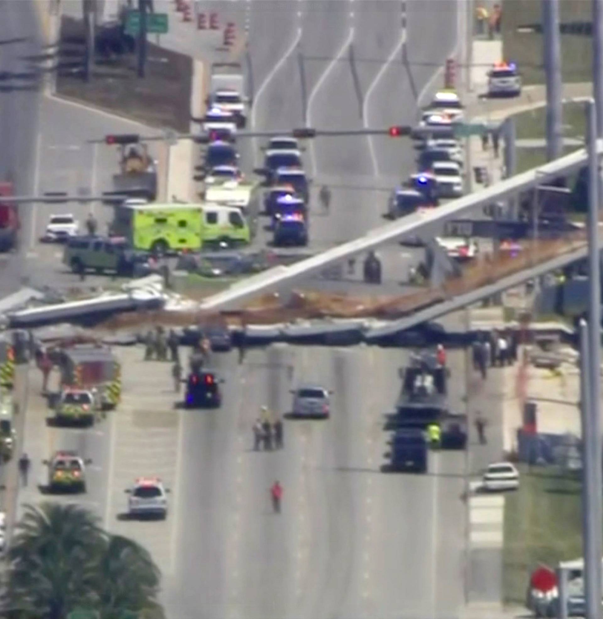 Emergency crews look for victims at the scene of a collapsed pedestrian bridge at Florida International University in Miami, Florida