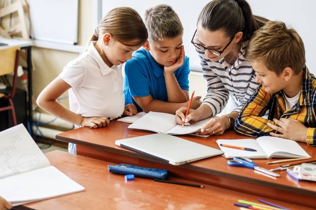 Female,Teacher,Helps,School,Kids,To,Finish,They,Lesson.they,Sitting