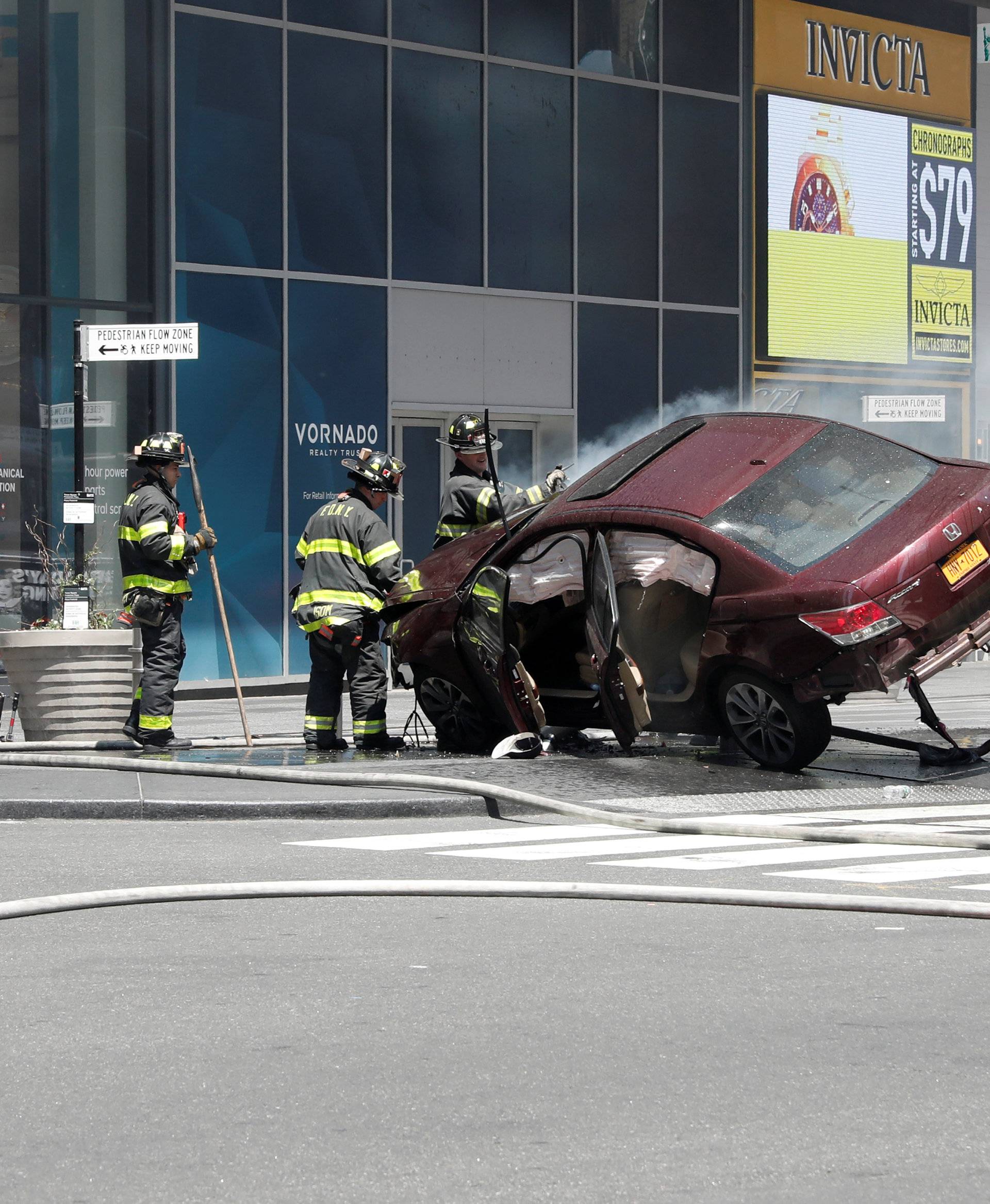 A vehicle that struck pedestrians and later crashed is seen on the sidewalk in New York City