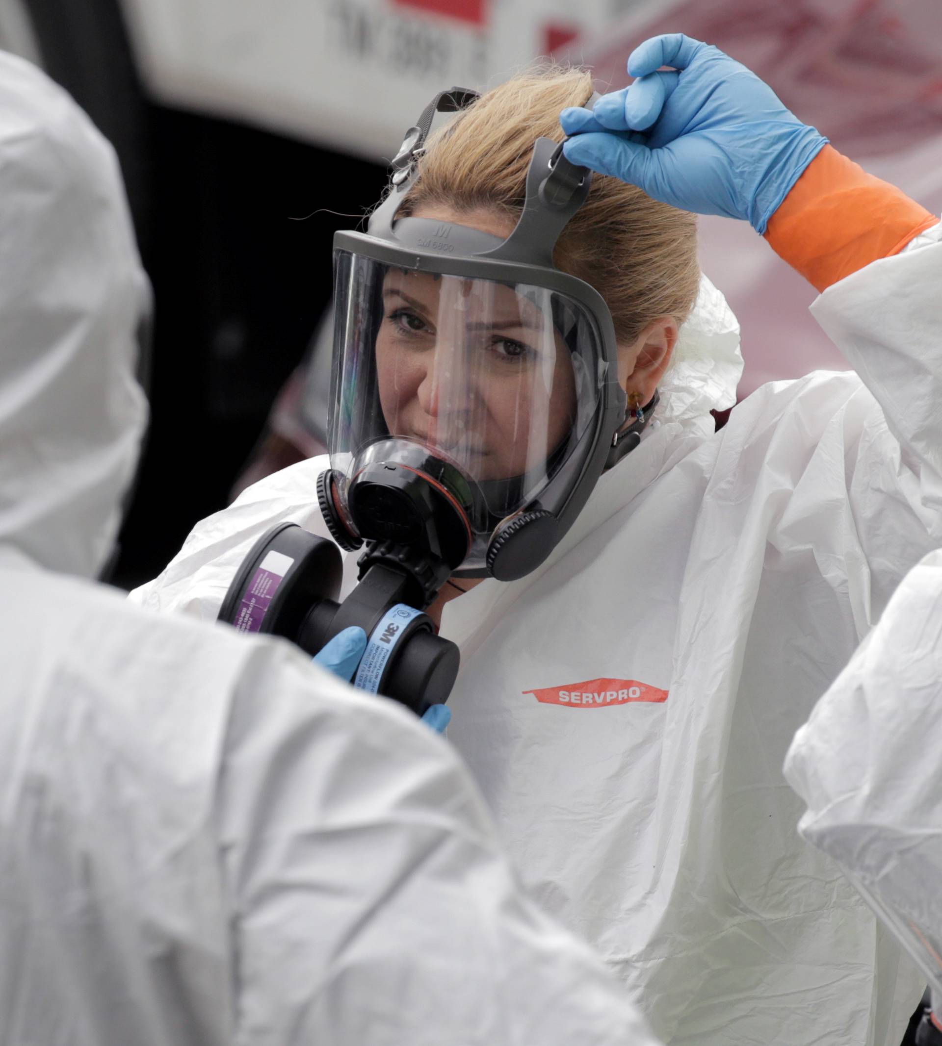 Members of a cleaning crew prepare to enter the Life Care Center of Kirkland, the Seattle-area nursing home at the epicenter of one of the biggest coronavirus outbreaks in the United States, in Kirkland