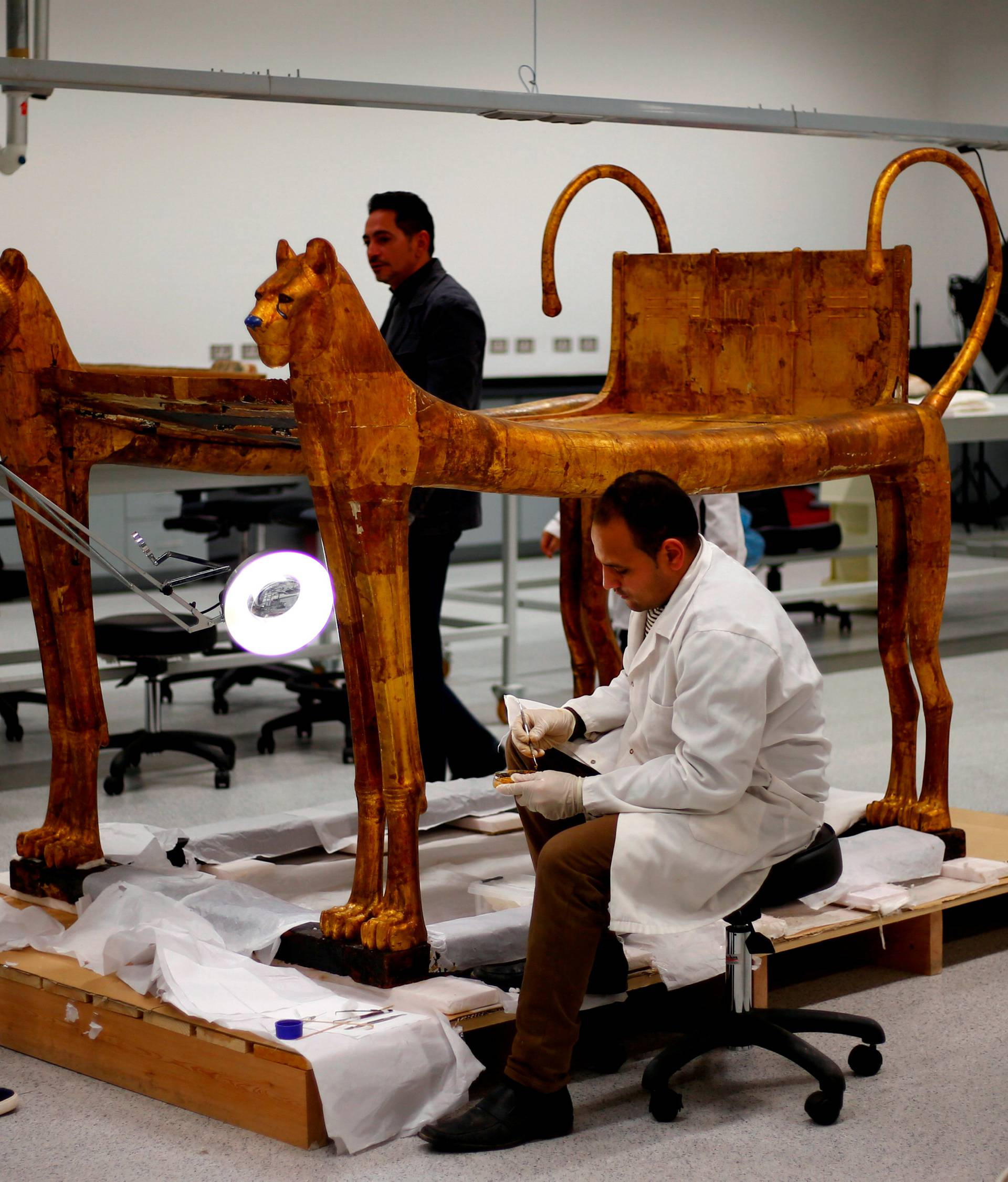 General manager of technical affairs Hussien Kamal looks on as the archaeological technicians work on the artefacts which belonged to The Golden King Tutankhamun, in the conservation centre of the Grand Egyptian Museum, on the outskirts of Cairo