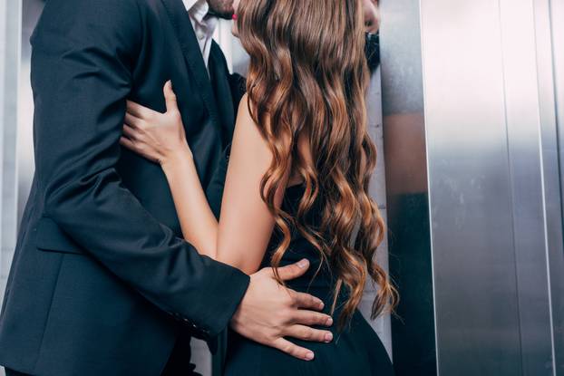 cropped view of couple passionately kissing near elevator