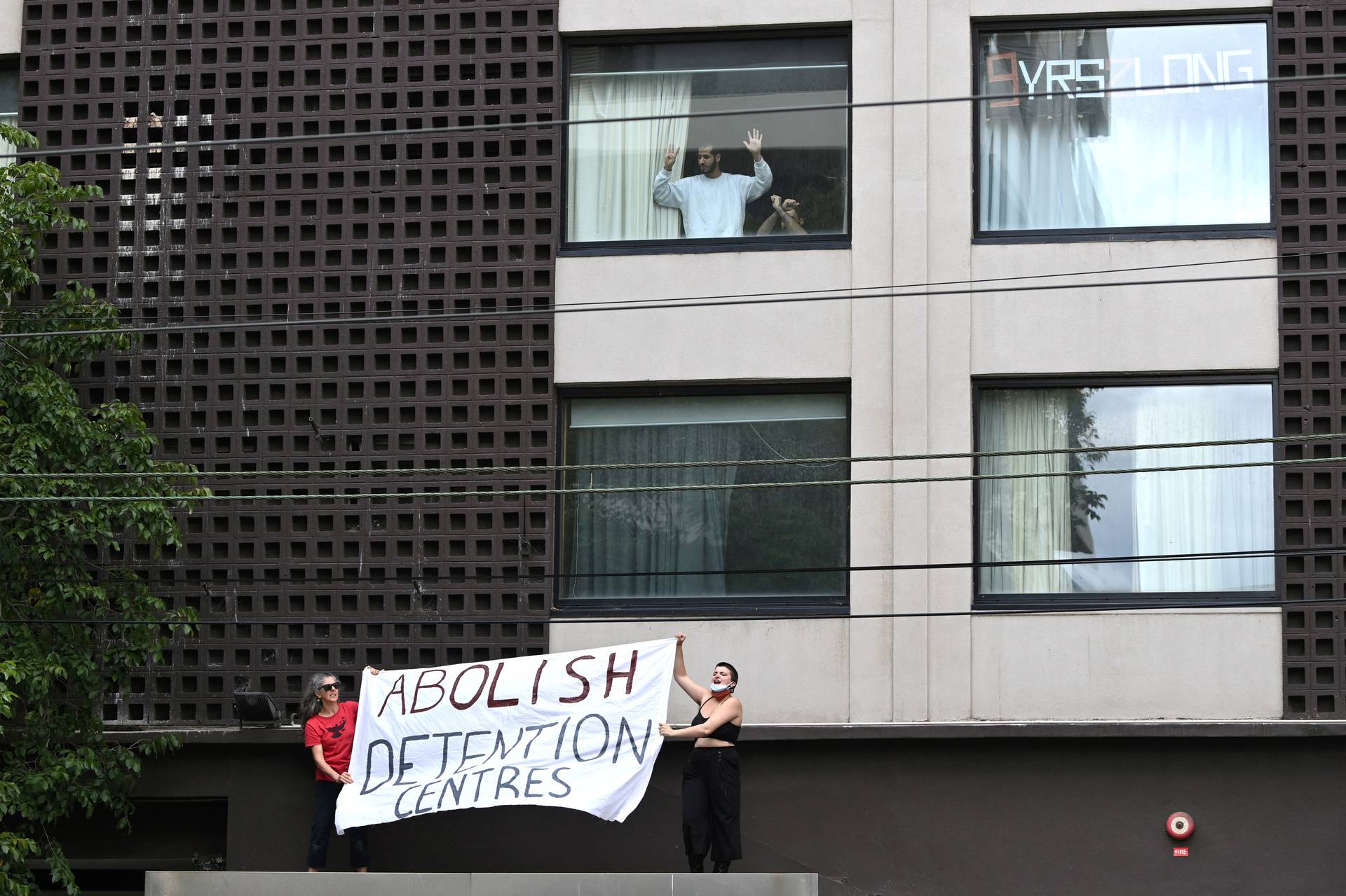 People protest outside the Park Hotel, believed to be holding Serbian tennis player Novak Djokovic in Melbourne