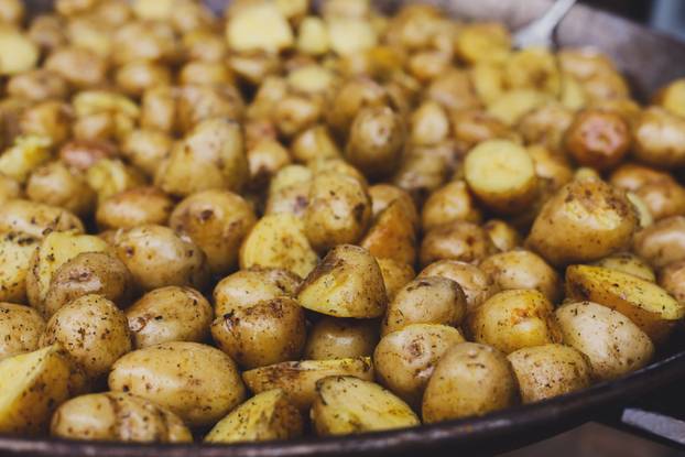 Roasted potatoes cooked in metal cauldron pot