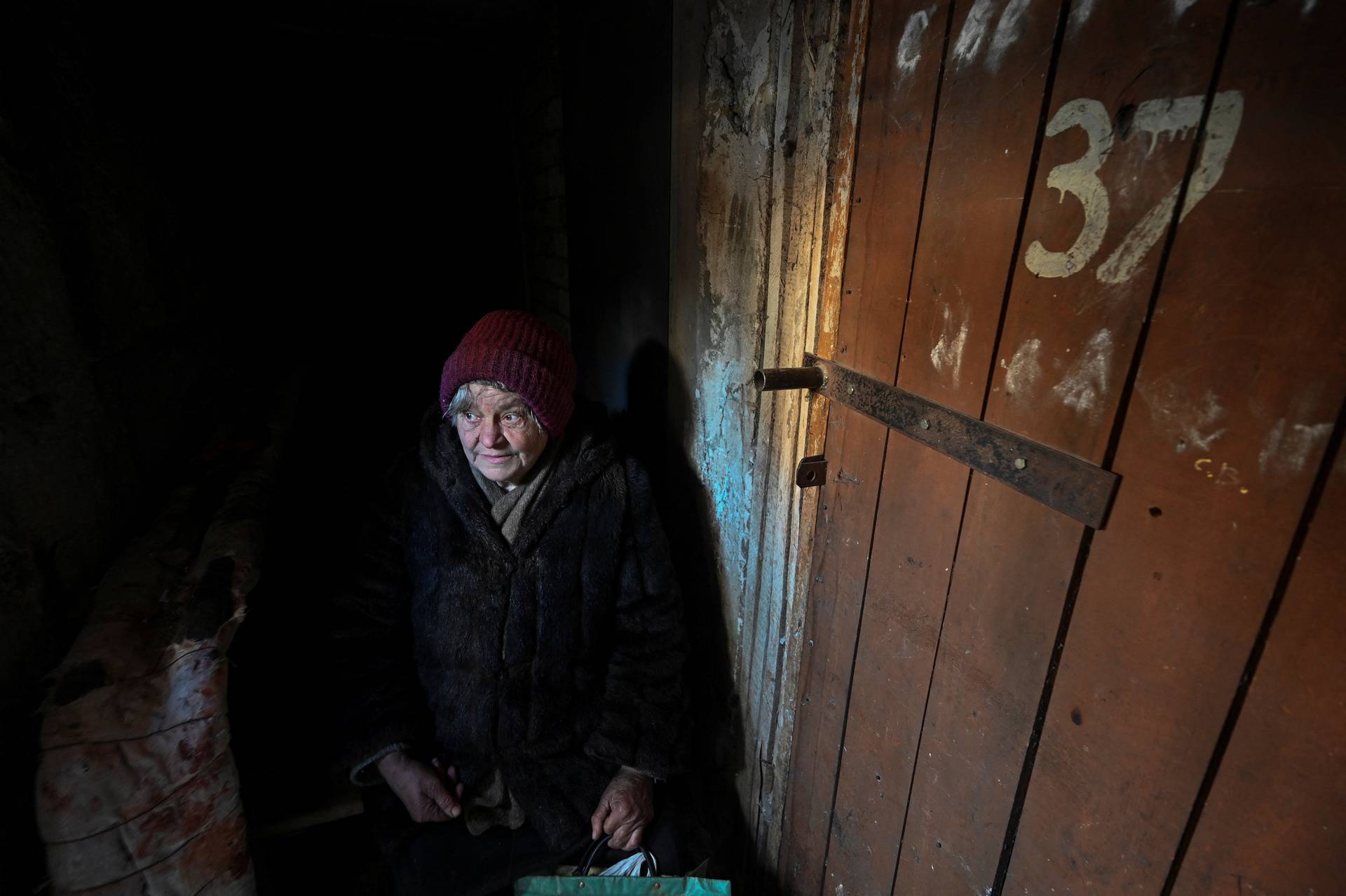 A woman sits inside an improvised shelter during a shelling in Sievierodonetsk