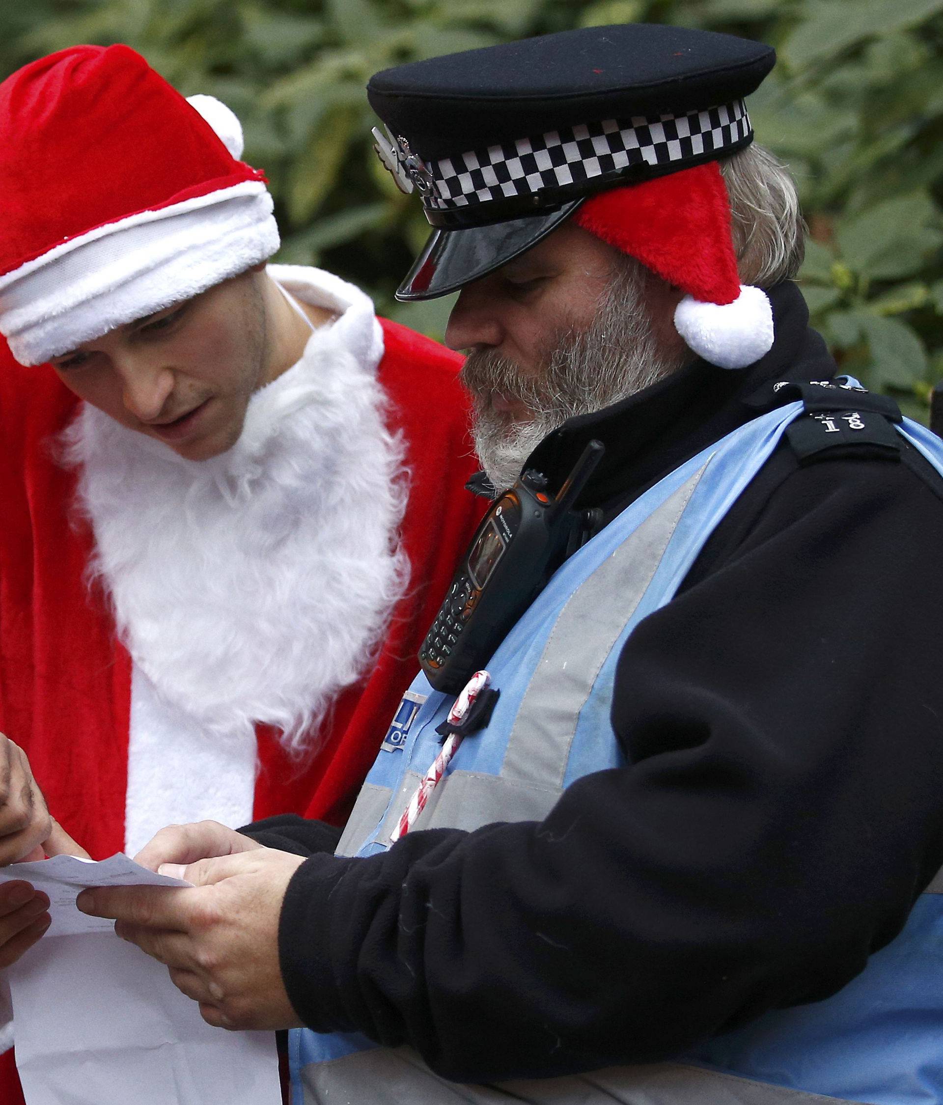 A man dressed as Santa Claus talks to a Police officer during the Santacon event in London