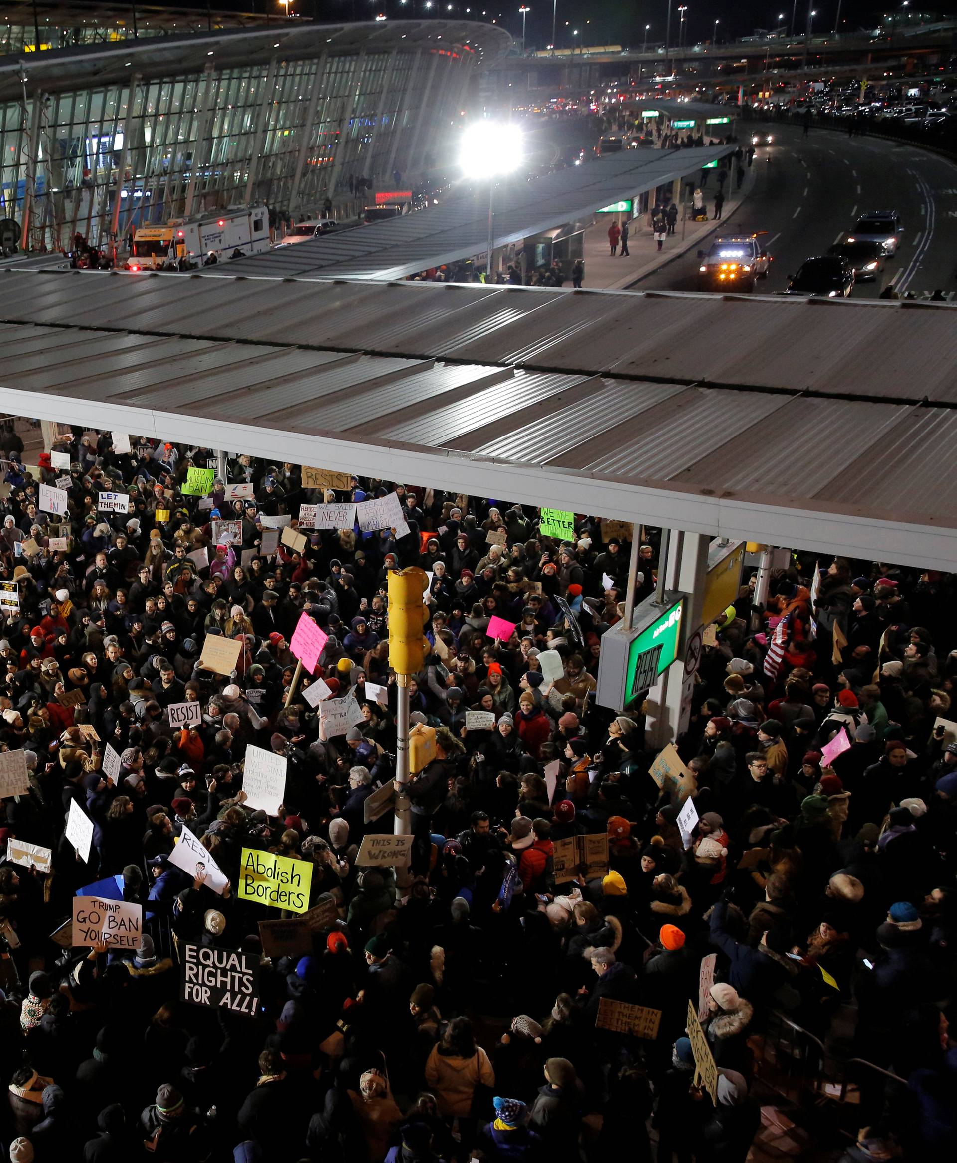 People participate in a protest against Donald Trump's travel ban outside Terminal 4 at John F. Kennedy International Airport in Queens, New York, U.S.