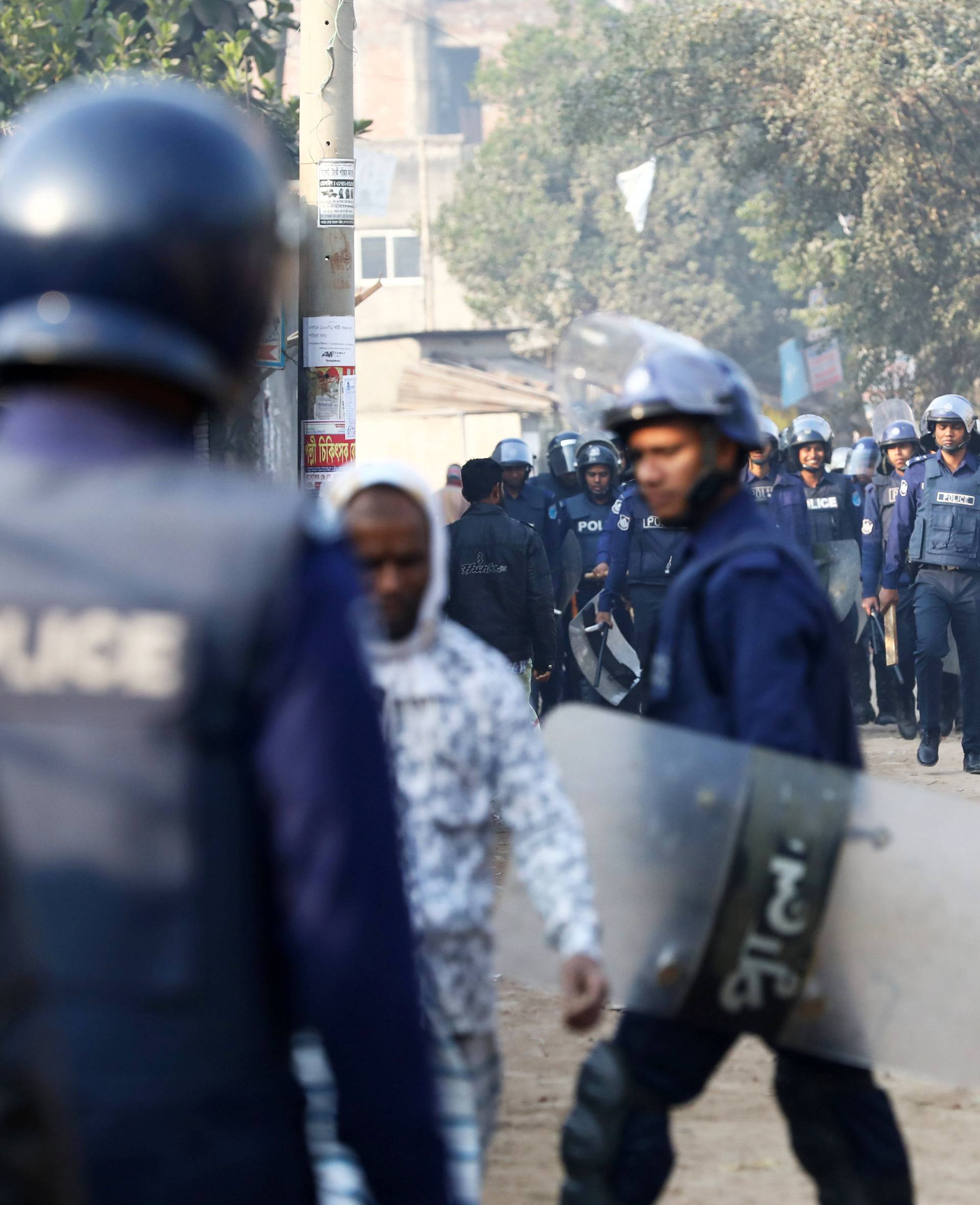 Policemen are seen patrolling the street while garments workers are protesting for higher wages at Ashulia, outskirt of Dhaka