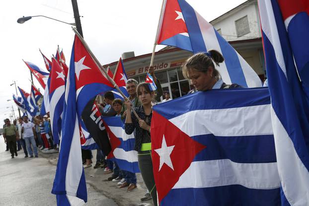 People line a road as they await the caravan carrying Fidel Castro