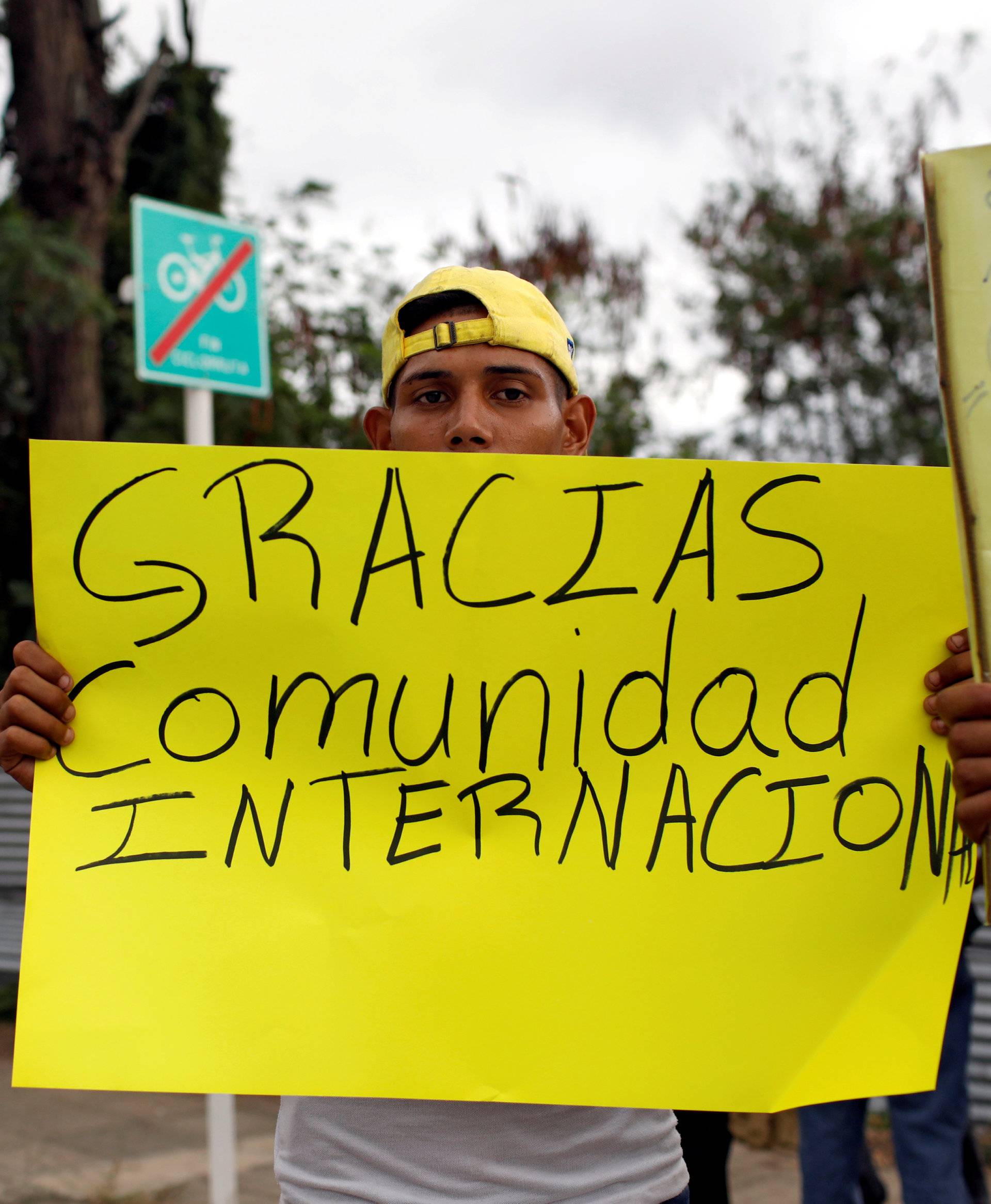 FILE PHOTO: A man holds a banner that reads "Thank you international community" near a warehouse where humanitarian aid for Venezuela is being stored