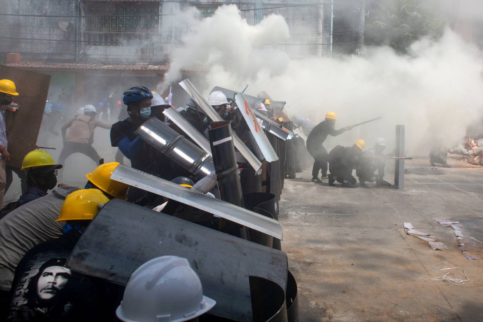 Protesters cover with makeshift shields during an anti-coup protest in Yangon