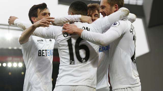 Swansea City's Gylfi Sigurdsson celebrates scoring their third goal with teammates