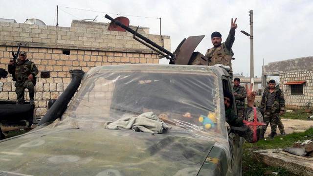 Syrian army soldiers gesture in southern Idlib province