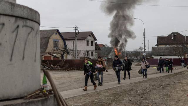 Local residents escape from the town of Irpin, after heavy shelling landed on the only escape route used by locals, as Russian troops advance towards the capital of Kyiv, in Irpin