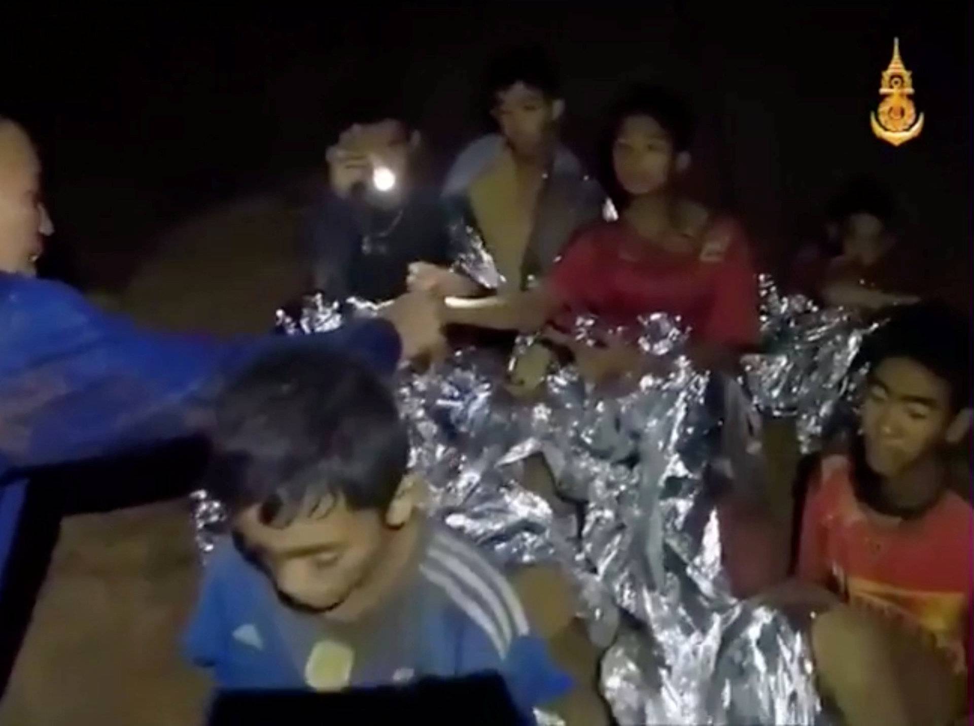 Boys from the under-16 soccer team trapped inside Tham Luang cave receive treatment from a medic in Chiang Rai, Thailand