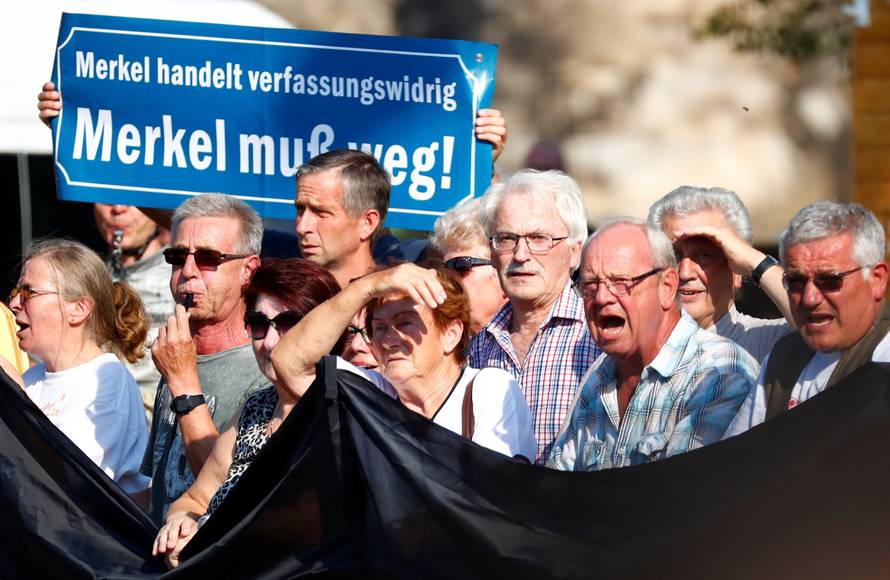 People take part in a protest against German Chancellor Angela Merkel as she visits the state parliament in Dresden