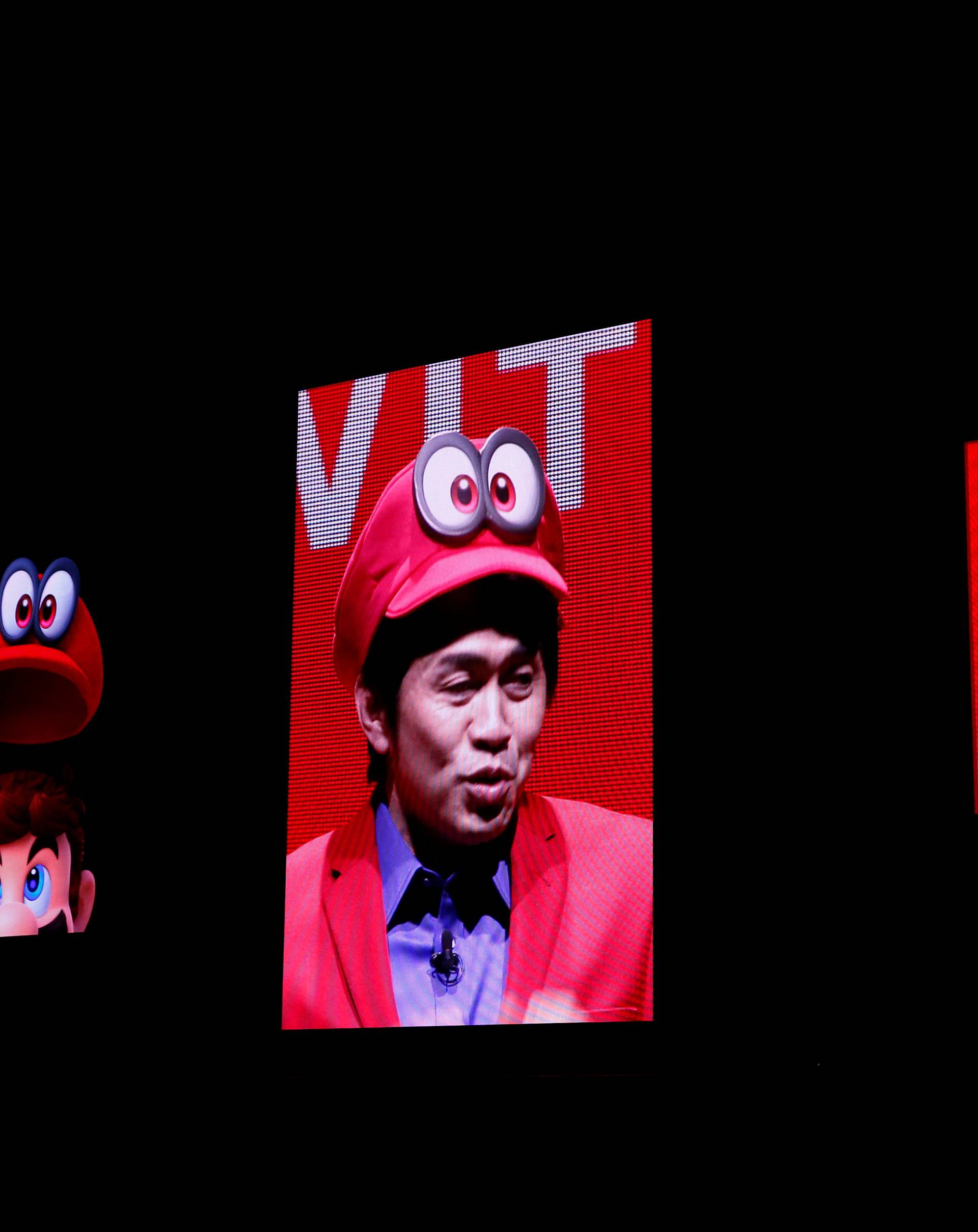 Nintendo's Yoshiaki Koizumi, wearing game character Super Mario's attire, speaks at the presentation ceremony of the Switch, its new game console, in Tokyo